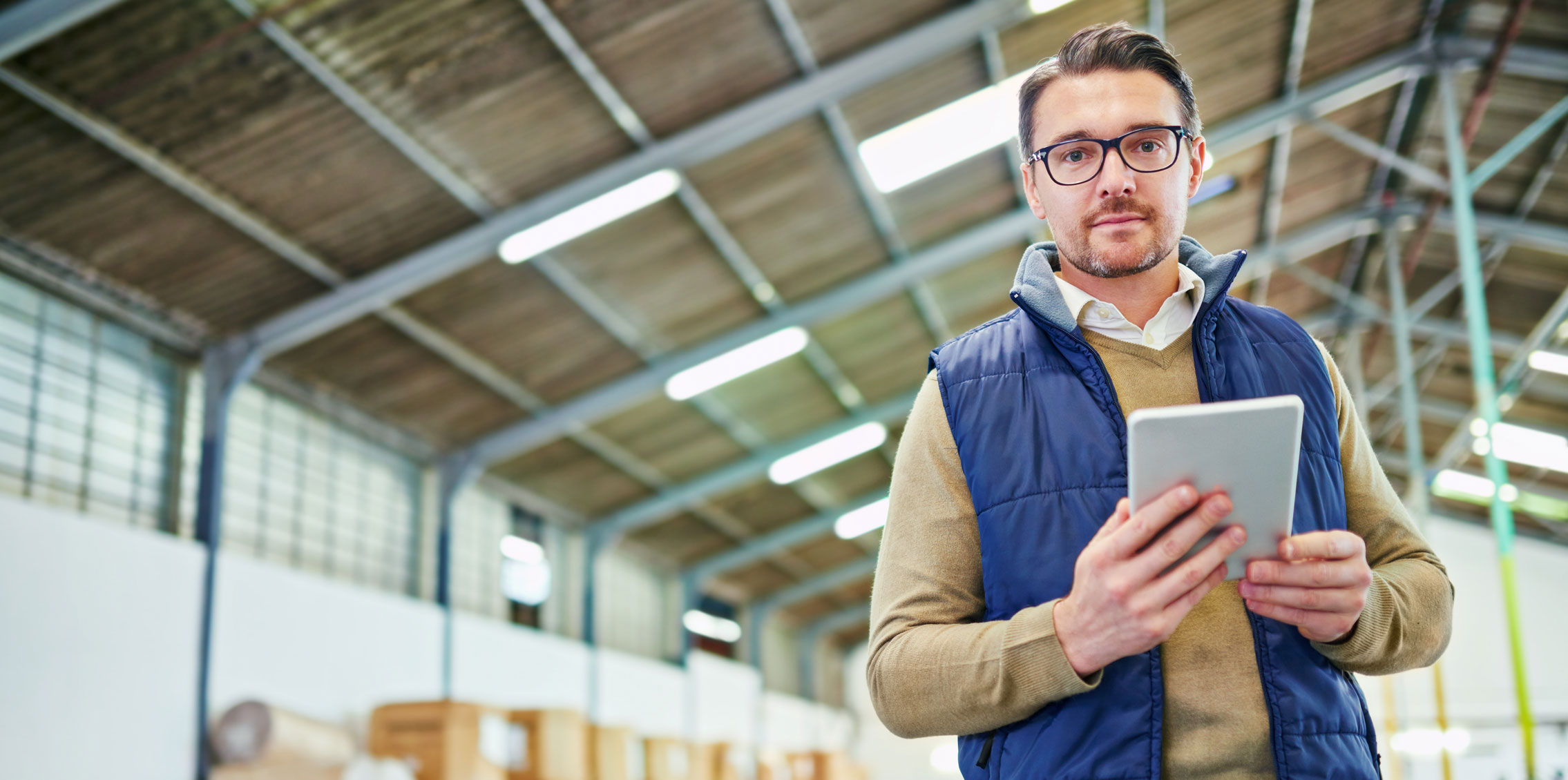 man in warehouse using tablet software for driving sales through targeted messaging